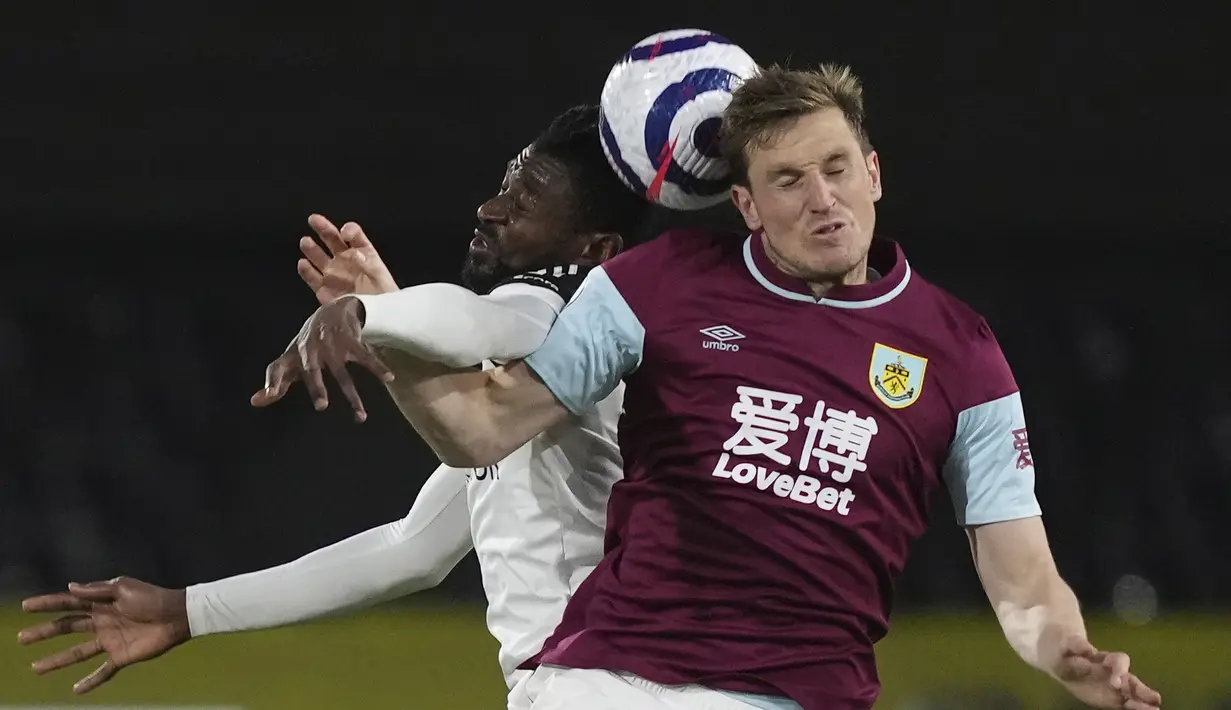 Striker Burnley, Chris Wood (kanan) berduel udara dengan gelandang Fulham, Andre-Frank Zambo Anguissa dalam laga lanjutan Liga Inggris 2020/2021 pekan ke-35 di Craven Cottage Stadium, London, Senin (10/5/2021). Burnley menang 2-0 atas Fulham. (AP/John Walton/Pool)