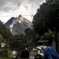 Orang-orang melihat Gunung Merapi yang memuntahkan batu dan abu di Yogyakarta (27/1/2021). BPPTKG menyatakan pada tanggal 27 Januari 2021 telah terjadi awan panas guguran di Gunung Merapi dengan jarak luncur maksimal 1200 meter ke arah hulu Sungai Krasak. (AFP/ Agung Supriyanto)