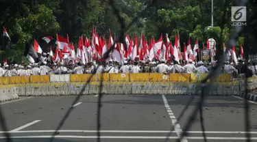 Massa aksi tertahan di belakang dua barikade yang dipasang pihak keamanan di Jalan Medan Merdeka Barat, Jakarta, Kamis (27/6/2019). Massa aksi berkumpul terkait pelaksanaan sidang putusan perselisihan hasil Pilpres 2019 di Gedung Mahkamah Konstitusi. (Liputan6.com/Helmi Fithriansyah)