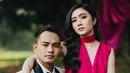 Dengan latar belakang pohon besar yang alami, dekorasi kain beludru berwarna magenta menambah kesan glamor dan klasik pada suasana alam terbuka.  [@terralogical @leurafilm].