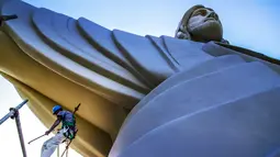 Seorang pekerja terlihat dekat patung Christ the Protector yang sedang dibangun di Encantado, negara bagian Rio Grande do Sul, Brasil, pada 29 Oktober 2021. Patung itu akan lebih besar dari Christ the Redeemer milik Rio de Janeiro dan menjadi tertinggi ketiga di dunia. (SILVIO AVILA / AFP)