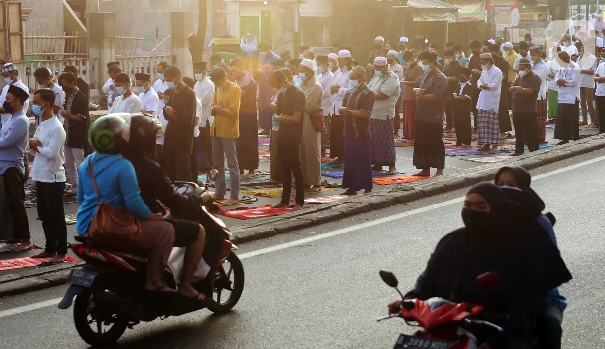 Sepeda motor melintas saat umat muslim melaksanakan salat Idul Adha 1442 H di Masjid Masjid Jami Al-Mubarok, Tangerang, Banten, Selasa (20/7/2021). Sebagian masjid melakukan pelaksanaan salat Idul Adha 1442 H, namun dengan protokol kesehatan yang ketat. (Liputan6.com/Angga Yuniar)