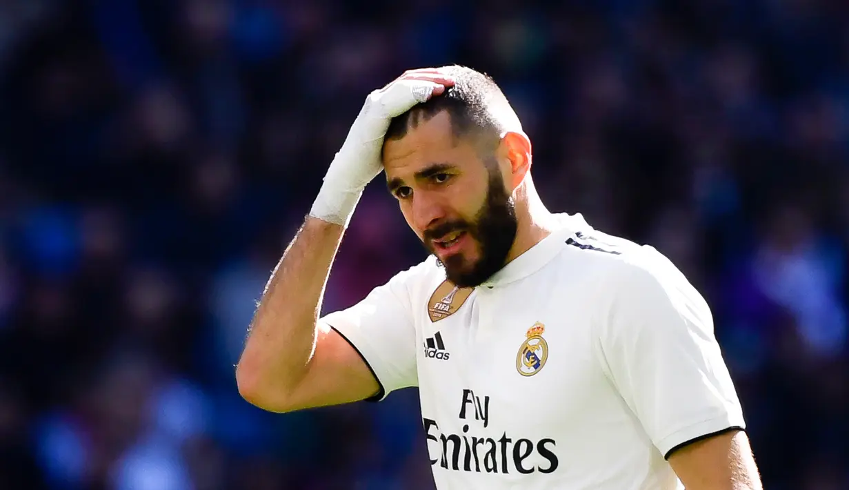 Ekspresi pemain depan Real Madrid Karim Benzema usai gagal mencetak gol ke gawang Girona dalam lanjutan La Liga di Stadion Santiago Bernabeu, Madrid, Spanyol, Minggu (17/2). Los Blancos kalah 1-2 dari Girona. (GABRIEL BOUYS/AFP)