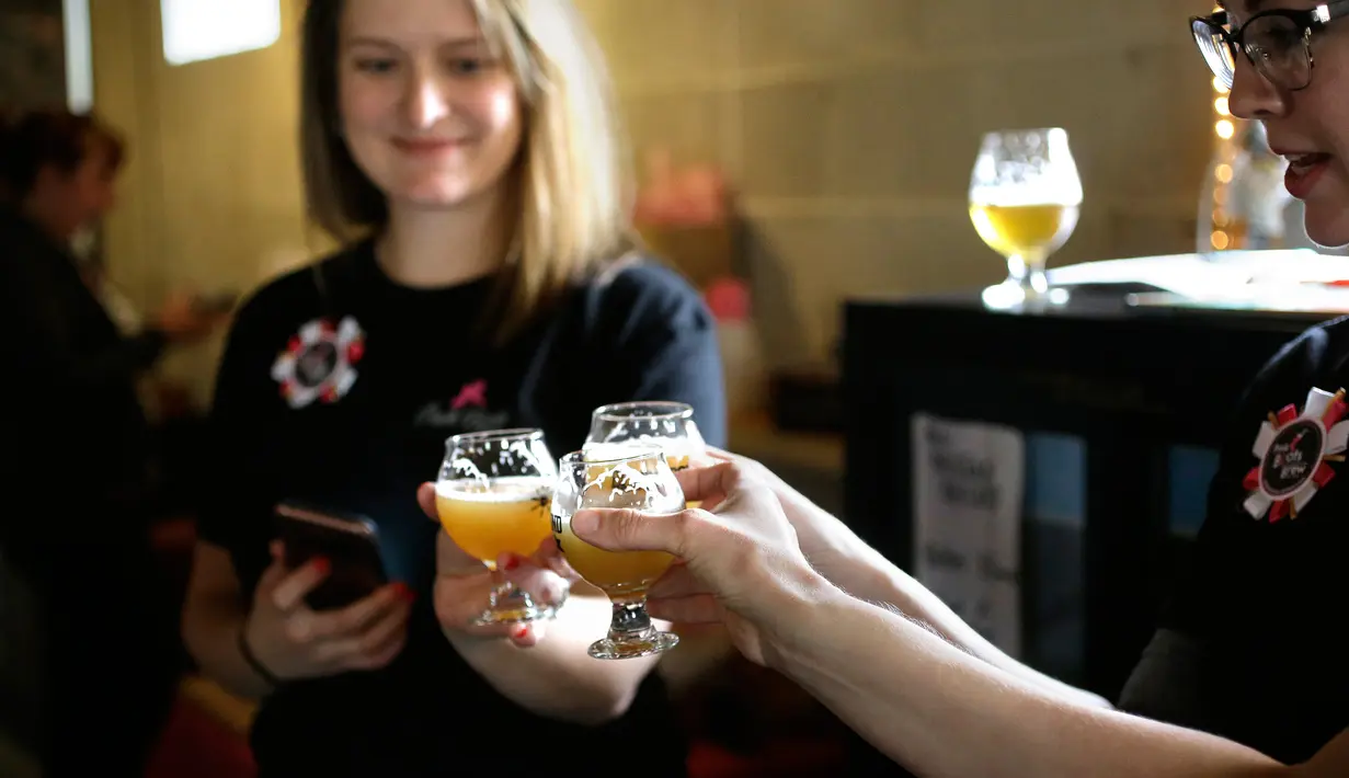 Sejumlah wanita bersulang saat meminum bir yang dibuatnya di tempat pembuatan bir di Black Pond Brews, Danielson (4/3). Pabrik bir ini menggelar acara bertajuk Pink Boots Society untuk menghormati Hari Perempuan Internasional. (AP Photo / Steven Senne)