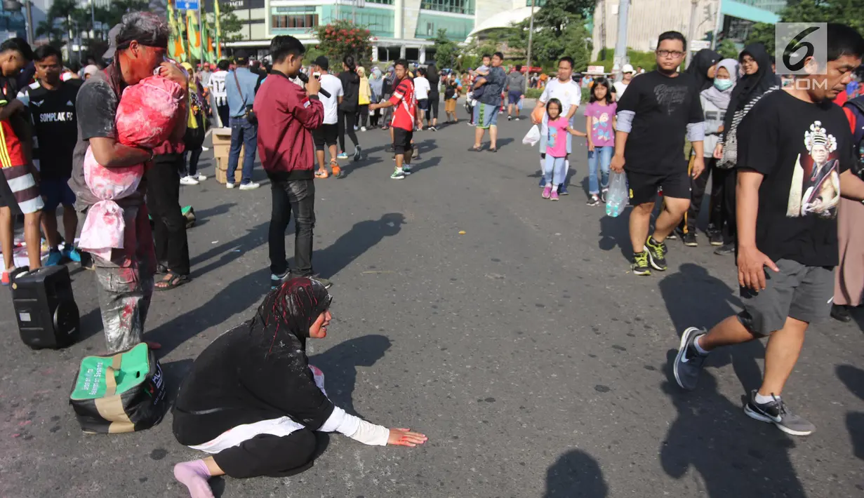 Dua relawan dari Aksi Cepat Tanggap (ACT) saat melakukan teatrikal tentang penderita rakyat Suriah yang menjadi korban peperangan di CFD Bundaran HI, Jakarta, Minggu (15/7). (Liputan6.com/Arya Manggala)