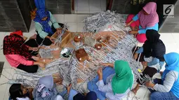 Sejumlah ibu membuat kerajinan tangan dari koran bekas di Kampung Sirnasari, Tanah Baru, Bogor, Rabu (13/2). Kerajinan tangan dengan label Salam Rancage ini sudah diekspor ke 9 negara dengan harga Rp 15 ribu - Rp 1,3 juta. (Merdeka.com/Arie Basuki)