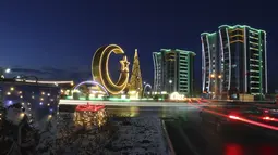 Pohon Natal, bulan sabit, dan bangunan apartemen yang didekorasi untuk perayaan Tahun Baru terlihat di alun-alun pusat di Argun, sekitar 17 km. (11 mil) timur Grozny, ibu kota republik Chechnya, Rusia, Kamis (23/12/2021). (AP Photo/Musa Sadulayev)