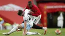 Pemain Manchester United Paul Pogba (kanan) berebut bola dengan pemain West Ham United Declan Rice pada pertandingan Liga Inggris di Old Trafford, Manchester, Inggris, Rabu (22/7/2020). Pertandingan berakhir dengan skor 1-1. (Clive Brunskill/Pool via AP)