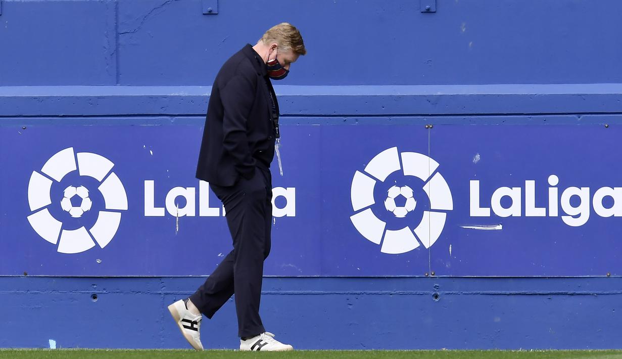 Pelatih Barcelona, Ronald Koeman, tertunduk lesu saat melawan Eibar pada laga Liga Spanyol di Stadion Ipurua, Sabtu (23/5/2021). Barcelona menang dengan skor 1-0. (AP/Alvaro Barrientos)
