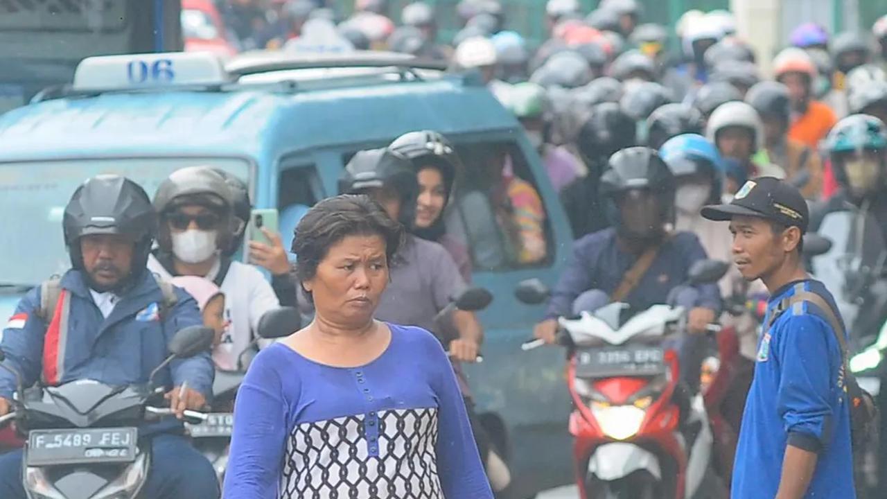 FOTO: Luapan Air Kali Baru di Depan Pasar Induk Kramat Jati Banjiri Jalan Raya Bogor, Lalu Lintas Macet Parah