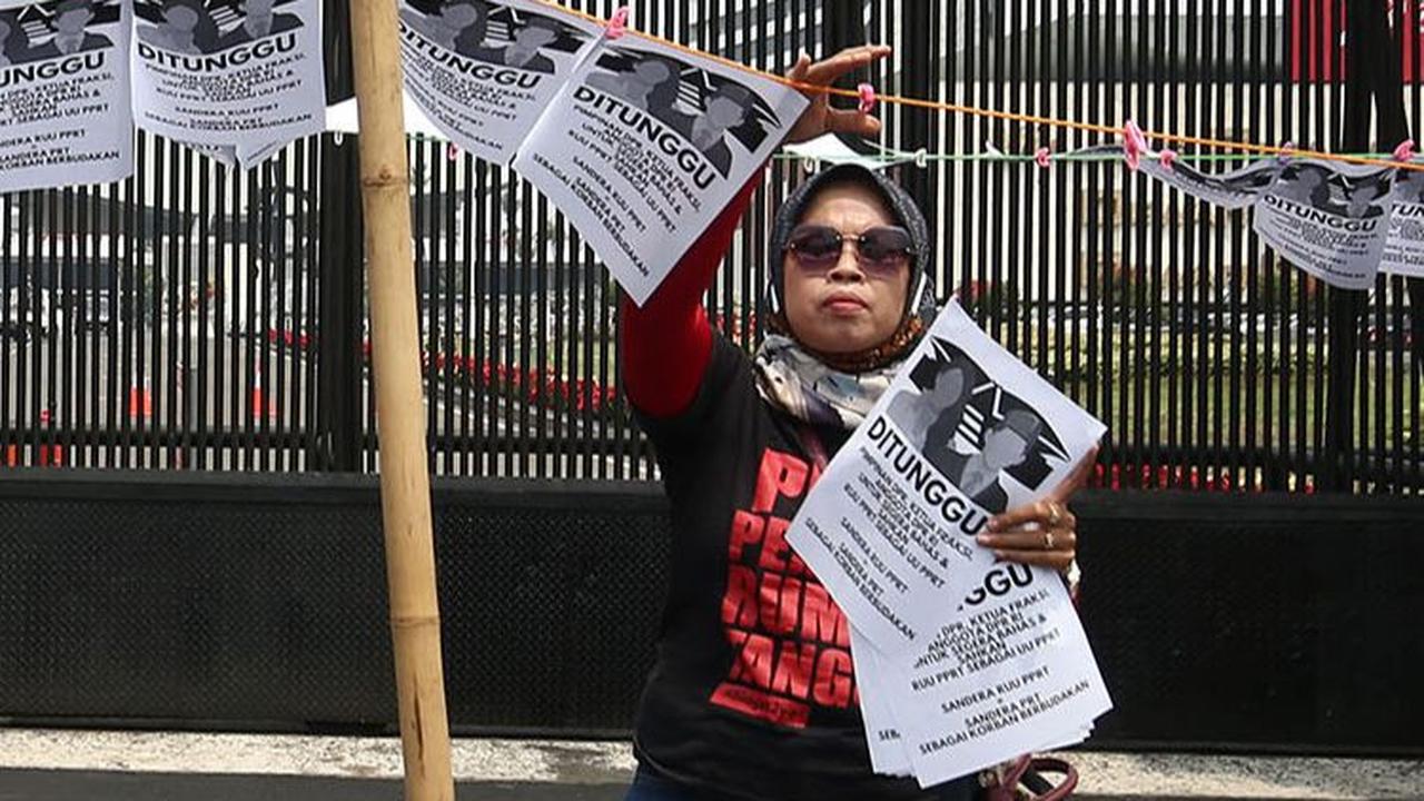 Dalam aksinya, massa PRT tampak memasang tali jemuran di depan Gedung DPR.