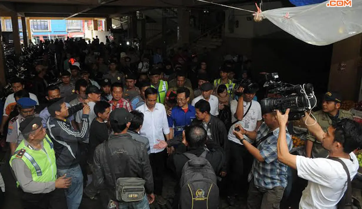 Meski harus berjubel dengan pengunjung pasar, Jokowi tetap berusaha untuk tersenyum ramah (Liputan6.com/Herman Zakharia)