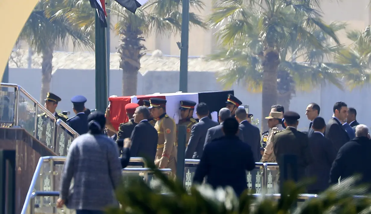 Para penjaga kehormatan membawa peti jenazah mantan presiden Hosni Mubarak saat upacara pemakaman di Masjid Tantawi, Kairo, Mesir, Rabu (26/2/2020). Mubarak dimakamkan di kampung halamannya, area sungai Nil. (Khaled DESOUKI/AFP)