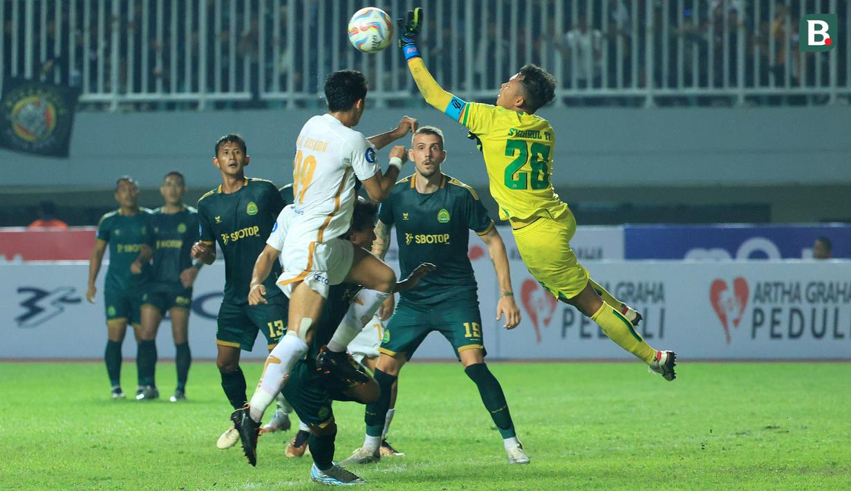 <p>Pemain Persija Jakarta, Aji Kusuma (kiri) berebut bola dengan kiper Persikabo 1973, Syahrul Trisna pada laga pekan kedua BRI Liga 1 2023/2024 di Stadion Pakansari, Cibinong, Bogor, Minggu (9/7/2023). (Bola.com/M Iqbal Ichsan)</p>