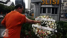 Polisi Korban Bom Thamrin Aiptu Denny Maheu, malakukan tabur bunga saat aksi damai "Peringatan 1 Tahun Tragedi Bom Thamrin 14 Januari 2016", di TKP Pos Polisi Perempatan Sarinah, Jalan Thamrin, Jakarta, Sabtu (14/1). (Liputan6.com/JohanTallo)