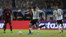 Pemain Venezuela Miguel Navarro (kiri) dan pemain Argentina Rodrigo De Paul memperebutkan bola pada pertandingan sepak bola kualifikasi Piala Dunia 2022 di Stadion La Bombonera, Buenos Aires, Argentina, 25 Maret 2022. Argentina menang 3-0. (JUAN MABROMATA/AFP)