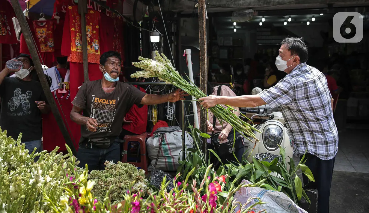 Penjual melayani pembeli bunga hias di Pasar Petak Sembilan, Glodok, Jakarta, Senin (31/1/2022). Jelang tahun baru Imlek 2573 sejumlah bunga seperti sedap malam, aster, mawar dan lainnya mulai banyak dicari warga Tionghoa untuk sembahyang. (Liputan6.com/Faizal Fanani)