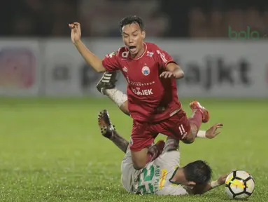 Pemain Persija Jakarta, Novri Setiawan jatuh saat dijegal pemain Persebaya, Abu Rizal (bawah) pada laga Gojek Liag 1 bersama Bukalapak di Stadion PTIK, Jakarta (26/6/2018). Persija dan Persebaya bermain imbang 1-1. (Bola.com/Nick Hanoatubun)