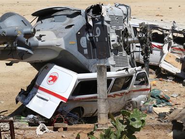 Sebuah helikopter milter Meksiko jatuh menimpa mobil van di Santiago Jamiltepec, negara bagian Oaxaca, Sabtu (17/2). Sedikitnya 13 orang tewas dalam kecelakaan helikopter yang mengangkut membawa pejabat tinggi tersebut. (AP/Luis Alberto Cruz Hernandez)
