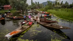 Para pria Kashmir menjual produk mereka di pasar sayur terapung di Danau Dal di Srinagar, Kashmir yang dikuasai India pada 26 Juli 2020. Sayuran yang diperdagangkan di pasar terapung ini disuplai ke Srinagar dan banyak kota di lembah Kashmir. (AP Photo/Dar Yasin)