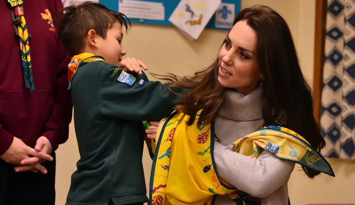 Seorang anak melilitkan kain Kate Middleton saat rekayasa pemberian pertolongon pertama dalam  acara Cub Scout Pack di Kings Lynn, Inggris (14/12). Kate memang dikenal sering berpartisipasi dalam acara Pramuka setiap tahunnya. (Reuters/Ben Stansall/Pool)