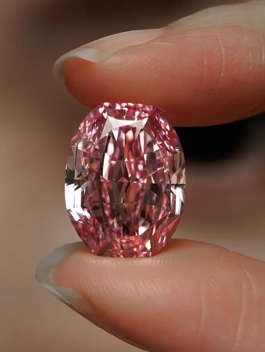 Model memperlihatkan berlian berwarna purple pink yang sangat langka di ruang lelang Sotheby Hong Kong pada 12 Oktober 2020. Berlian 14,83 karat tersebut merupakan potongan karat berlian pink terbesar yang pernah ditemukan di Rusia. (AP Photo/Vincent Yu)