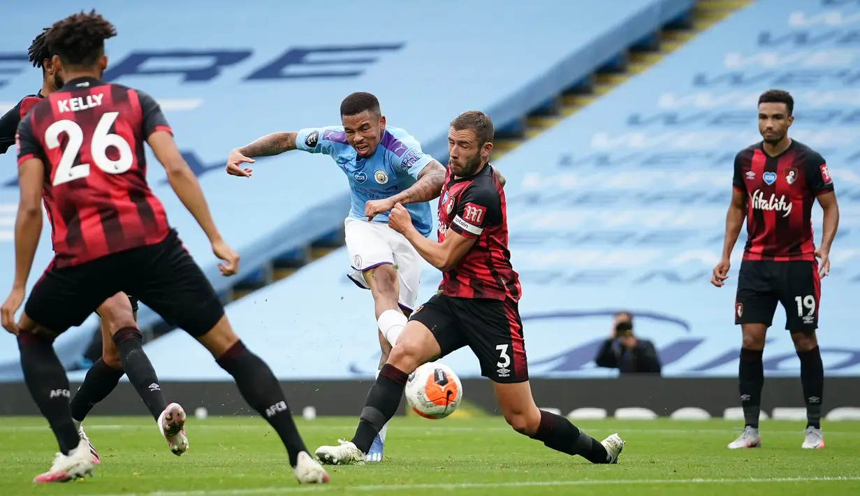 Striker Manchester City, Gabriel Jesus, melepaskan tendangan ke arah gawang Bournemouth, Jack Stacey, pada laga lanjutan Premier League pekan ke-36 di Etihad Stadium, Kamis (16/7/2020) dini hari WIB. Manchester City menang 2-1 atas Bournemouth. (AFP/Dave Thompson/pool)