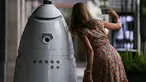 Seorang wanita berswafoto bersama robot keamanan baru yang bernama ROD2 di River Oaks District, Houston (18/8). Robot baru ini menjadi tambahan untuk tim pengaman dan patroli rutin di River Oaks District. (Michael Ciaglo / Houston Chronicle via AP)