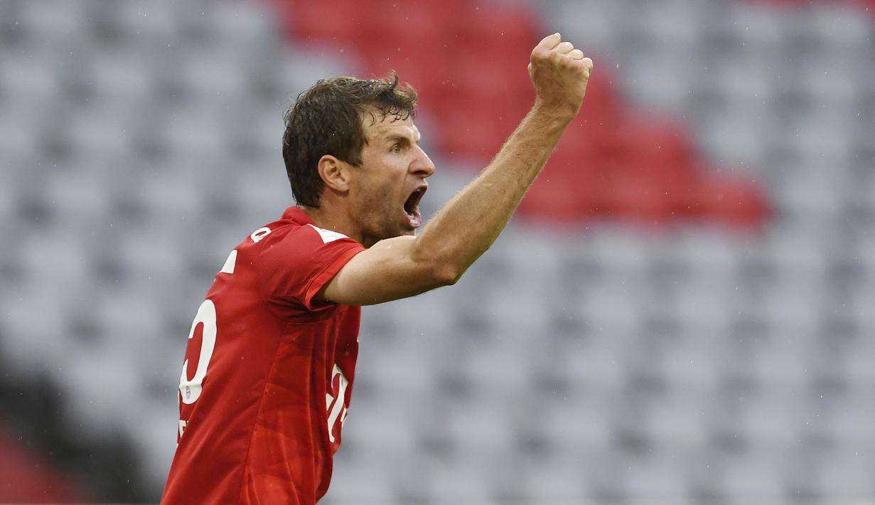 Pemain Bayern Munchen, Thomas Muller, melakukan selebrasi usai membobol gawang Eintracht Frankfurt pada laga Bundesliga di Allianz Arena, Minggu (24/5/2020). Bayern Munchen menang 5-2 atas Eintracht Frankfurt. (AP/Andreas Gebert)