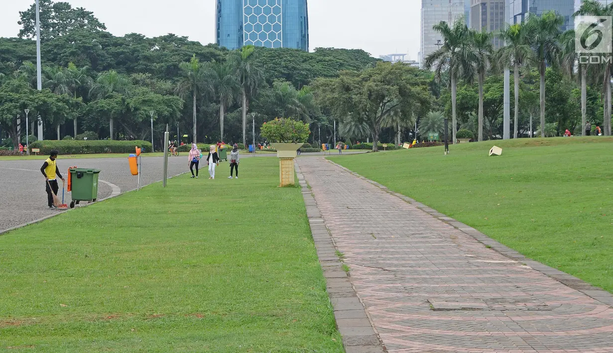 Petugas membersihkan taman di kawasan Monas, Jakarta, Rabu (23/1). Sejumlah taman di kawasan Monas rencananya akan ditata ulang. (Liputan6.com/Herman Zakharia)