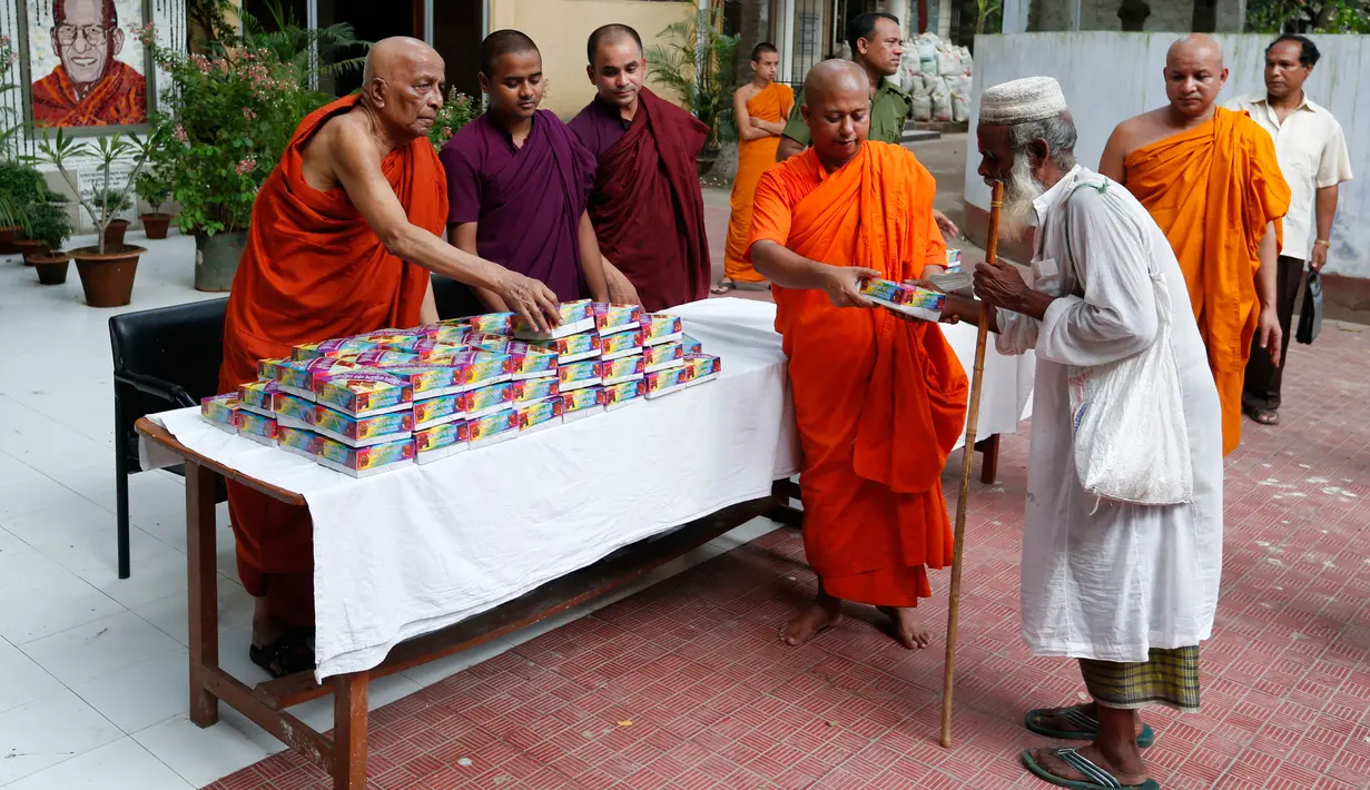 Biksu memberikan makanan untuk berbuka puasa Ramadan kepada umat muslim yang kurang mampu di wihara Budha di Dhaka, Bangladesh (9/6). Menurut pejabat setempat, hal tersebut merupakan contoh harmoni sosial antar dua agama. (AP Photo/A.M. Ahad)