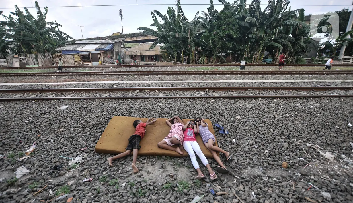 Anak-anak saat bermain di dekat rel kereta api di kawasan Bahari Ujung, Tanjung Priok, Jakarta Utara, Selasa (24/5/2022). Minimnya fasilitas dan ruang terbuka hijau di kawasan tersebut menyebabkan anak-anak setempat memilih bermain di sekitar perlintasan kereta api yang dapat membahayakan keselamatan mereka. (merdeka.com/Iqbal S Nugroho)
