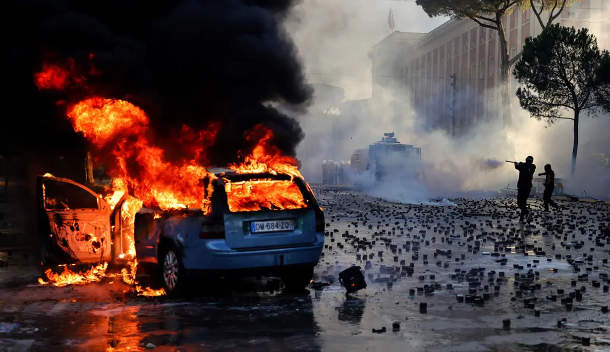 Sebuah mobil terbakar saat bentrokan pecah dalam aksi demonstrasi antipemerintah di luar kantor Perdana Menteri di Tirana, Albania, Sabtu (17/10/2026). (AP Photo/Hameraldi Agolli)