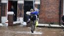 Petugas penyelamat mengevakuasi warga di Carlisle, Inggris, Minggu (6/12). Puluhan ribu rumah tidak punya listrik karena Badai Desmond yang menyebabkan banjir di Inggris utara dan sebagian wilayah Skotlandia. (REUTERS/Phil Noble)