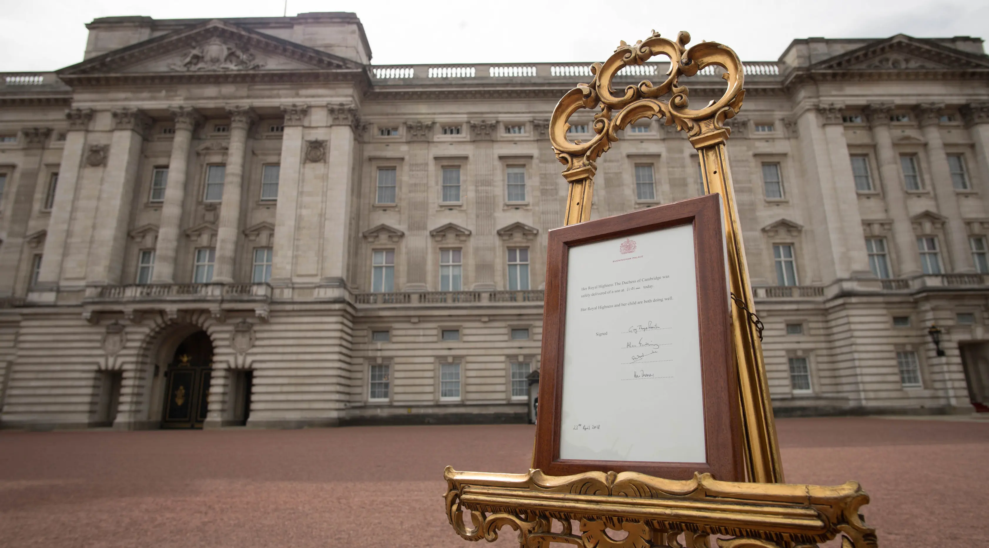 Pengumuman kelahiran bayi baru kerajaan terpajang di halaman depan Istana Buckingham, London, Inggris, Senin (23/4). Kate Middleton tampil di depan umum tujuh jam usai melahirkan. (Pool Photo via AP)