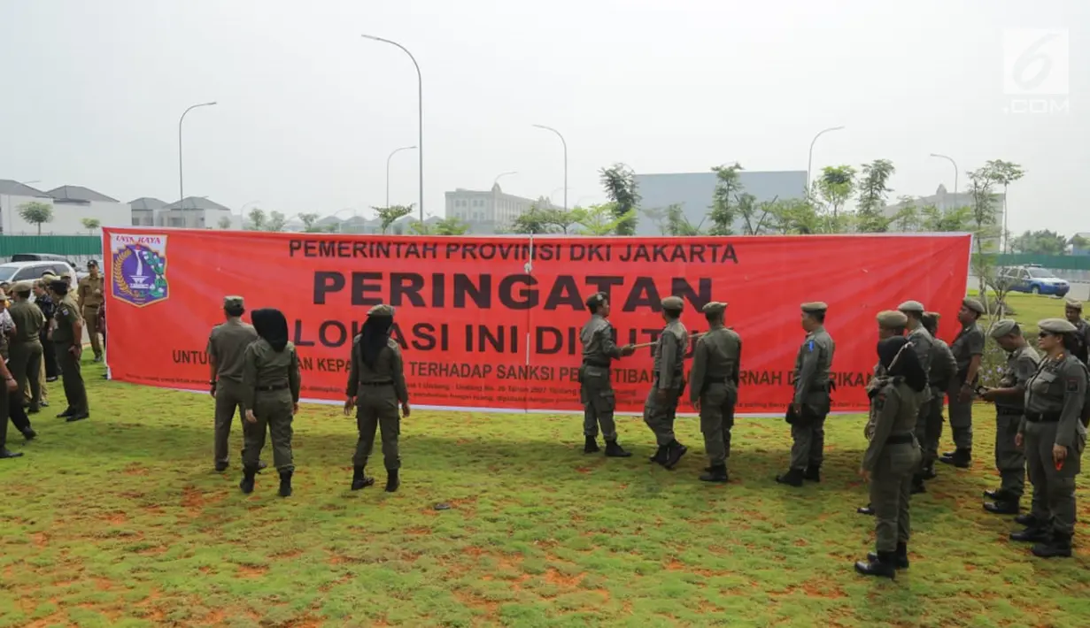Personel Satpol PP memasang spanduk penyegelan bangunan di Pulau Reklamasi, Teluk Jakarta, Kamis (7/6). Dalam imbauannya, Gubernur DKI Anies Baswedan meminta Satpol PP melakukan penyegelan secara beradab. (Liputan6.com/HO/Deka Wira Saputra)
