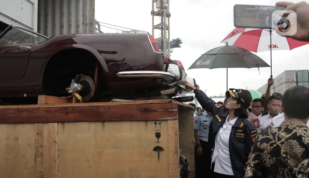 Menkeu Sri Mulyani mengecek barang bukti kasus penyelundupan mobil dan motor mewah di Terminal Petikemas Koja, Jakarta, Selasa (17/12/2019). Barang bukti yang diamankan merupakan hasil pengungkapan tujuh kasus kurun waktu 2016-2019 dengan total Rp 21 miliar. (merdeka.com/Iqbal Nugroho)