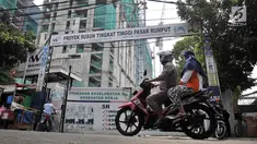Pengendara sepeda motor melintas di depan proyek Rusun Tingkat Tinggi Pasar Rumput di Jakarta, Selasa (20/3). Aktivitas proyek Rusun Pasar Rumput dihentikan sementara pascainsiden jatuhnya besi pada 18 Maret lalu. (Merdeka.com/Iqbal Nugroho)