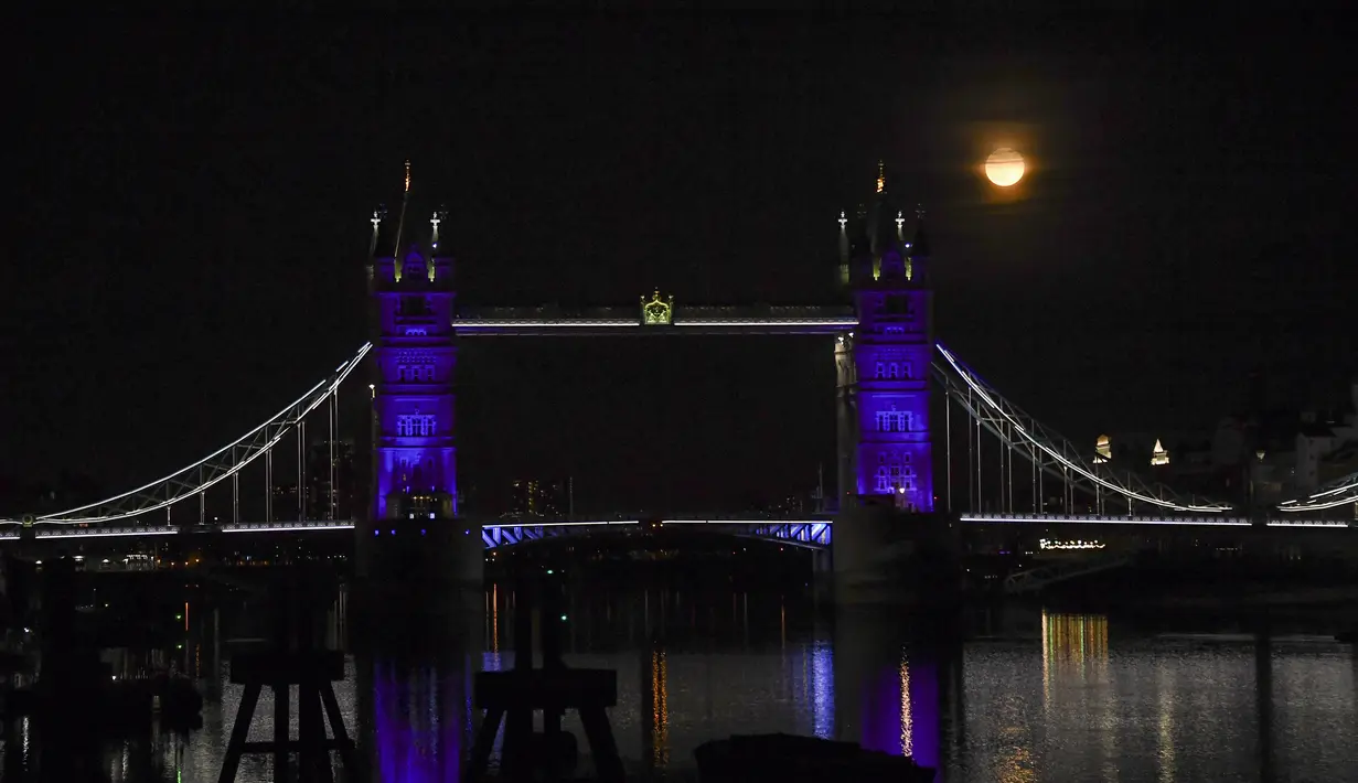 Bulan purnama terlihat di atas Tower Bridge, London, Inggris, Kamis (7/5/2020). Fenomena supermoon atau di belahan Bumi lain disebut flower moon ini merupakan yang terakhir di tahun 2020. (AP Photo/Alberto Pezzali)