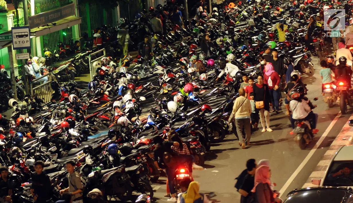 Deretan motor yang terparkir di ruas jalan Medan Merdeka Timur, Jakarta, Minggu (31/12). Akibat banyaknya motor yang parkir, ruas jalan Medan Merdeka Timur menyempit dan terjadi kemacetan panjang. (Liputan6.com/Helmi Fithriansyah)