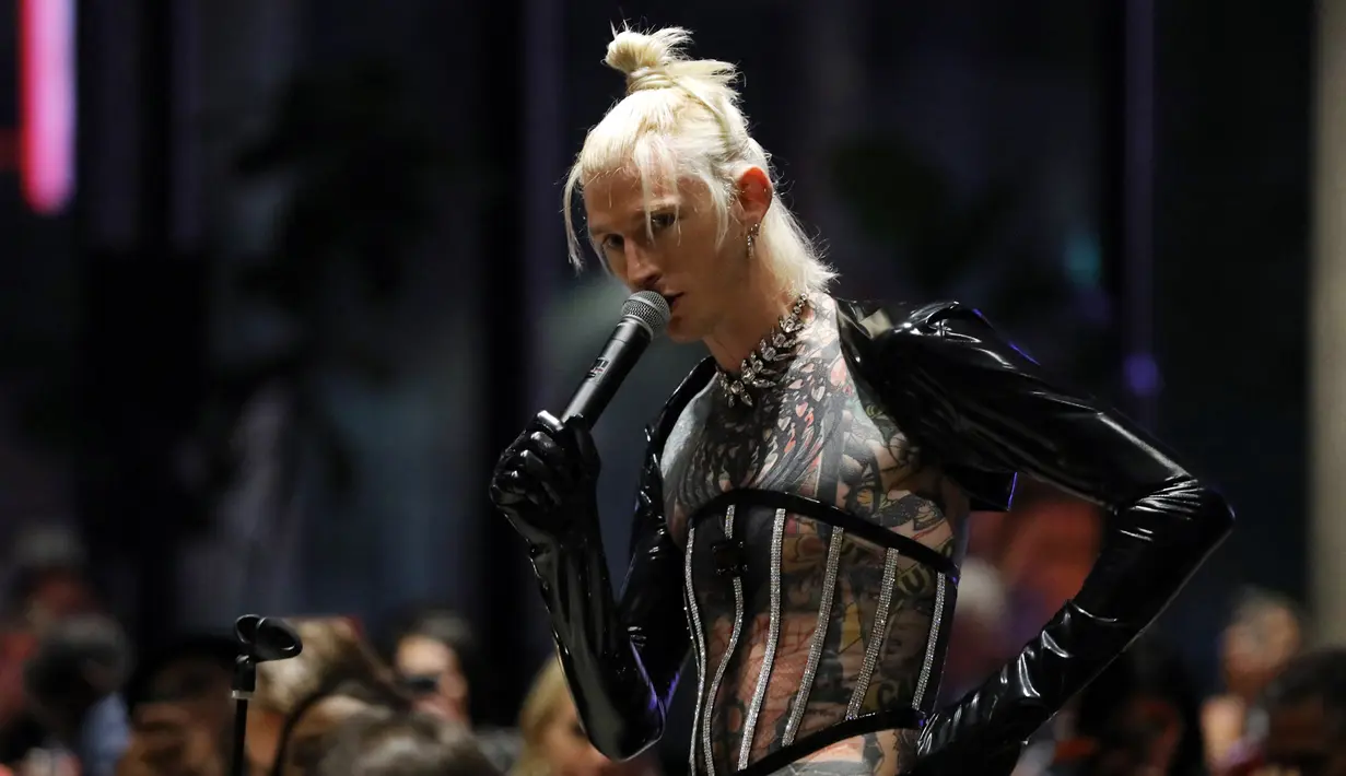 Machine Gun Kelly saat menghadiri Time100 Next Gala di SECOND Floor, New York City, Amerika Serikat, 25 Oktober 2022. Korset tembus pandang dari Dolce & Gabbana memperlihatkan area perut dan tatonya. (JP Yim/Getty Images for TIME/AFP)