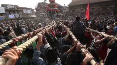 Umat Hindu Nepal menarik kereta kayu dewa Bhairava yang melewati kerumunan saat festival Bisket Jatra di Bhaktapur, Nepal (10/4). Festival ini diadakan untuk menandai Tahun Baru Nepal. (AFP Photo/Prakash Mathema)