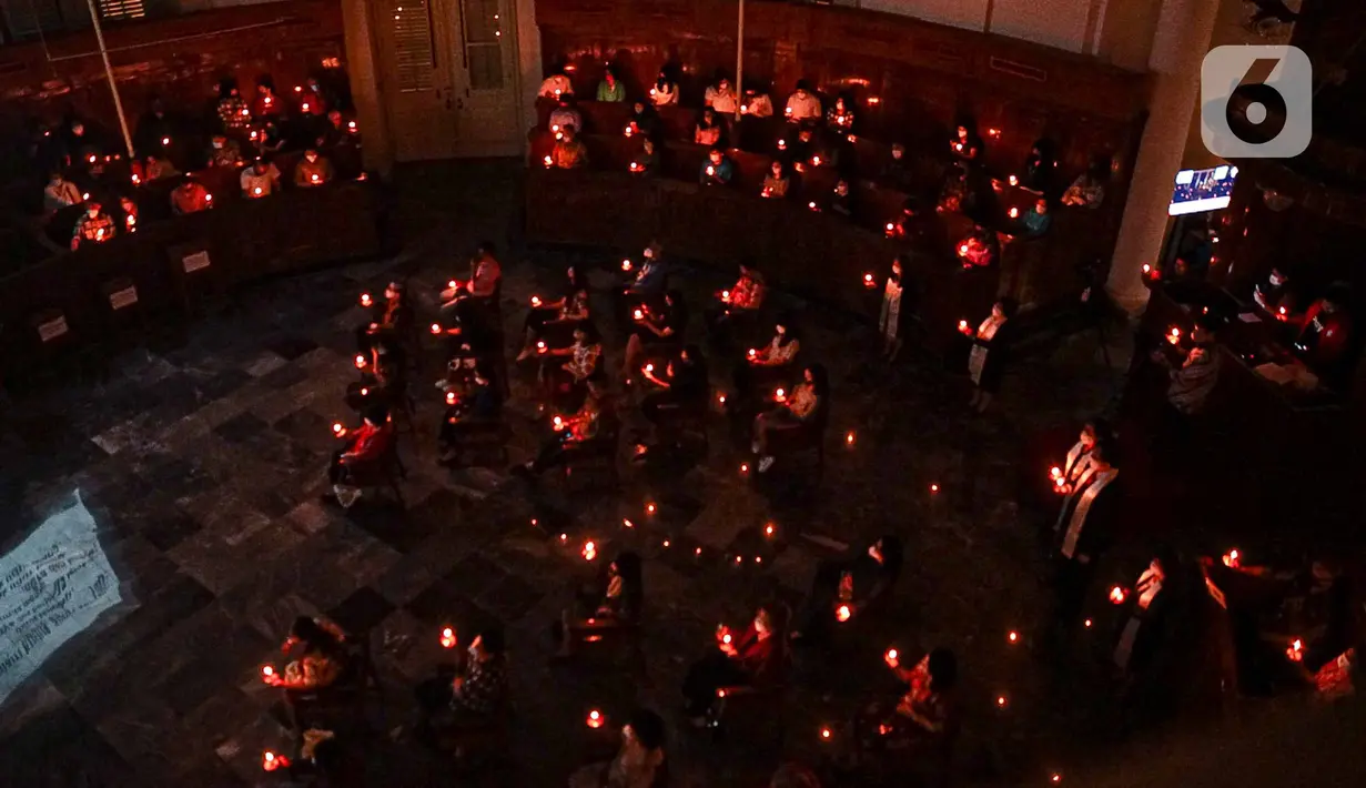 Jemaat melaksanakan ibadah malam Natal di Gereja Immanuel, Jakarta, Jumat (24/12/2021). Perayaan ibadah malam Natal mengingatkan umat untuk saling mengasihi dengan segenap hati dalam kasih persaudaraan yang tulus dan ikhlas melalui tindakan belarasa. (Liputan6.com/Faizal Fanani)