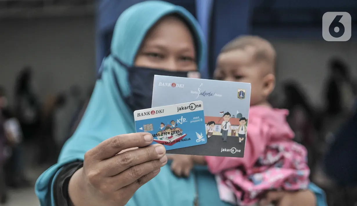 Orangtua dari anak penerima saat menunjukkan KJP yang baru diterima di kawasan Matraman, Jakarta, Selasa (24/11/2020). Penyaluran KJP plus tahap kedua ini menggunakan data baru berdasarkan pembaruan berkas warga penerima yang rampung pada bulan Oktober lalu. (merdeka.com/Iqbal S. Nugroho)