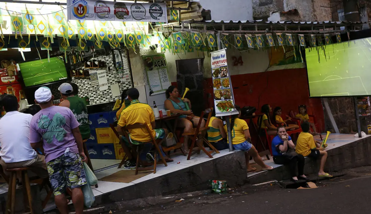Di pemukiman kumuh, Pavao-Pavaozinho, Rio de Janeiro, warga berkumpul di salah satu toko yang menyediakan televisi berikut layar lebar untuk melihat aksi Neymar dkk berlaga melawan Kamerun, (23/6/2014). (REUTERS/Ricardo Moraes)