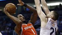 Forward Houston Rockets, Trevor Ariza (kiri), melepas tembakan dengan center Phoenix Suns Alex Len coba memblok pada laga NBA 2017-2018 di Talking Stick Resort Arena, Kamis (16/11/2017) atau Jumat (17/11/2017) WIB. (AP Photo/Ross D. Franklin)