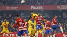 Bek Barcelona Gerard Pique melompat saat berebut bola dengan gelandang Granada Maxime Gonalons dalam jornada ke-20 Liga Spanyol 2021/2022 di Stadion Los Carmenes, Minggu (9/1/2022) dini hari WIB. Barcelona ditahan imbang 1-1 Granada. (AP Photo/Fermin Rodriguez)