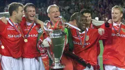 Selebrasi para pemain Manchester United dengan trofi juara setelah mengalahkan Bayern Munchen pada laga final Liga Champions 1998/1999 di Camp Nou Stadium, Barcelona (26/5/1999). Pada laga tersebut Bayern Munchen kalah 1-2 setelah sempat unggul 1-0 hingga injury time. (AFP/Eric Cabanis)