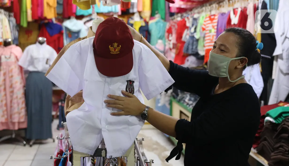 Pedagang merapikan seragam sekolah baru dagangannya di salah satu toko di Tangerang, Banten, Selasa (2/6/2020). Menjelang tahun ajaran baru, sejumlah pedagang di tempat tersebut mengeluh karena omzet penjualan seragam sekolah menurun drastis akibat pandemi COVID-19. (Liputan6.com/Angga Yuniar)