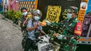 Anggotan TNI membagika masker kepada pengendara sepeda motor di Sunter Muara, Tanjung Priok, Jakarta, Selasa (9/2/2021). Tujuan kegiatan tersebut agar masyarakat menyadari peran penting penggunaan masker dalam memutus mata rantai penyebaran COVID-19. (Liputan6.com/Faizal Fanani)